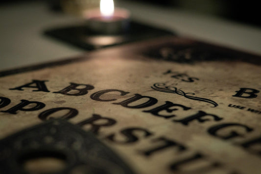 Close up of a Ouija board with a candle. 