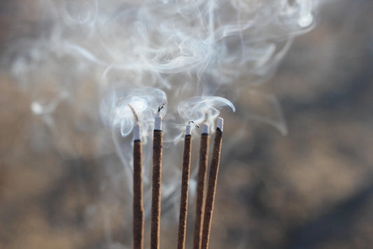 Burning stick incense with a smoky background. 