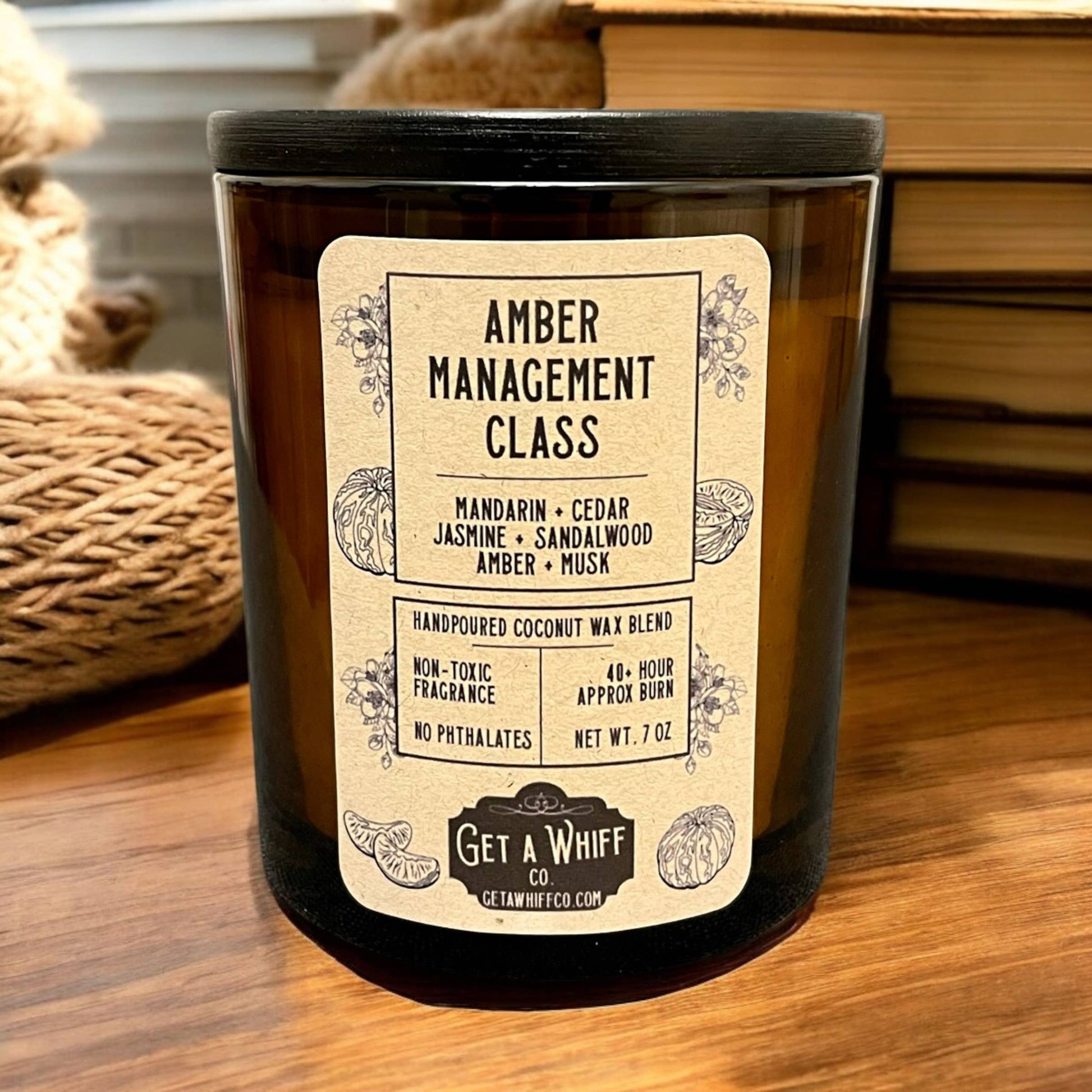 Candle with glass jar that says Amber Management Class.