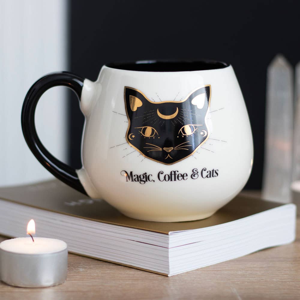 Rounded mug with 'Magic Coffee & Cats' text on a book with a candle in the background- Shadowplay Collection Gift Shop