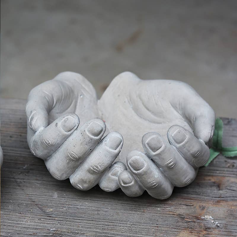 Cement sculpture of hands on a grey background- Shadowplay Collection Gift Shop