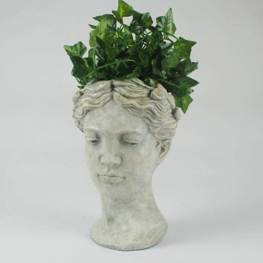 Decorative planter shaped like a woman's head with greenery on a white background