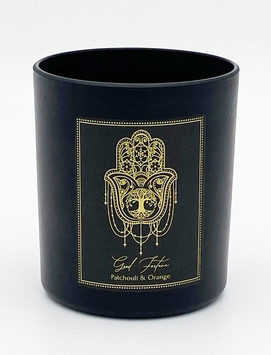 Black candle with gold Hamsa Hand design and text on a white background- Shadowplay Collection Gift Shop