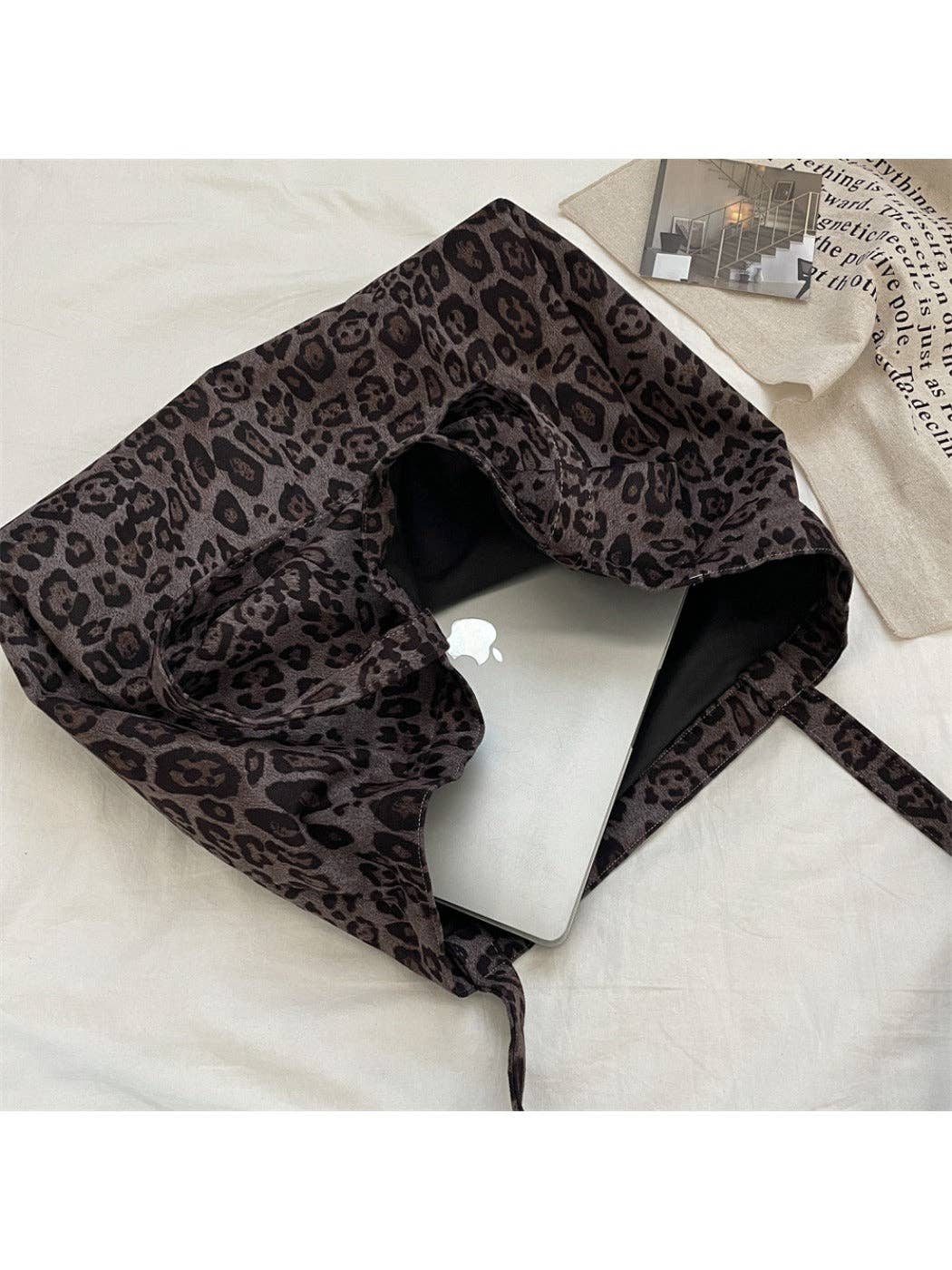 Leopard print towel draped over a white surface with a laptop in the bag. - Shadowplay Collection Gift Shop