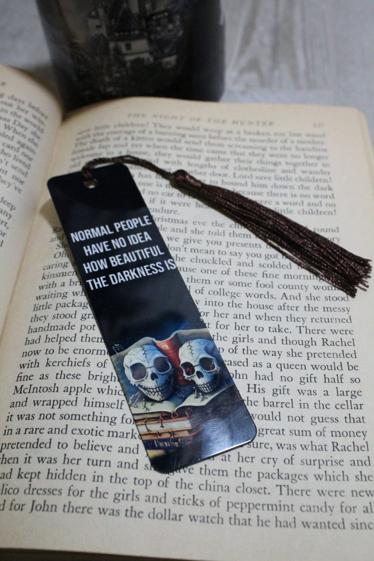 Bookmark with two skulls design and text on an open book