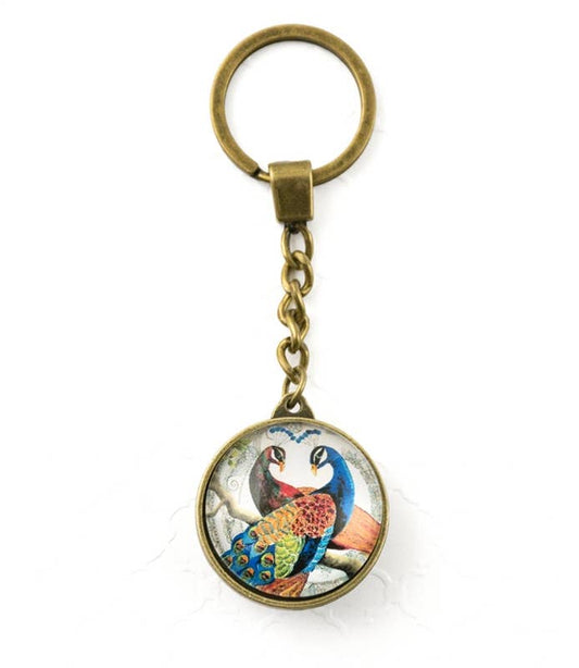 Keychain with a colorful peacock design on a white background- Shadowplay Collection Gift Shop