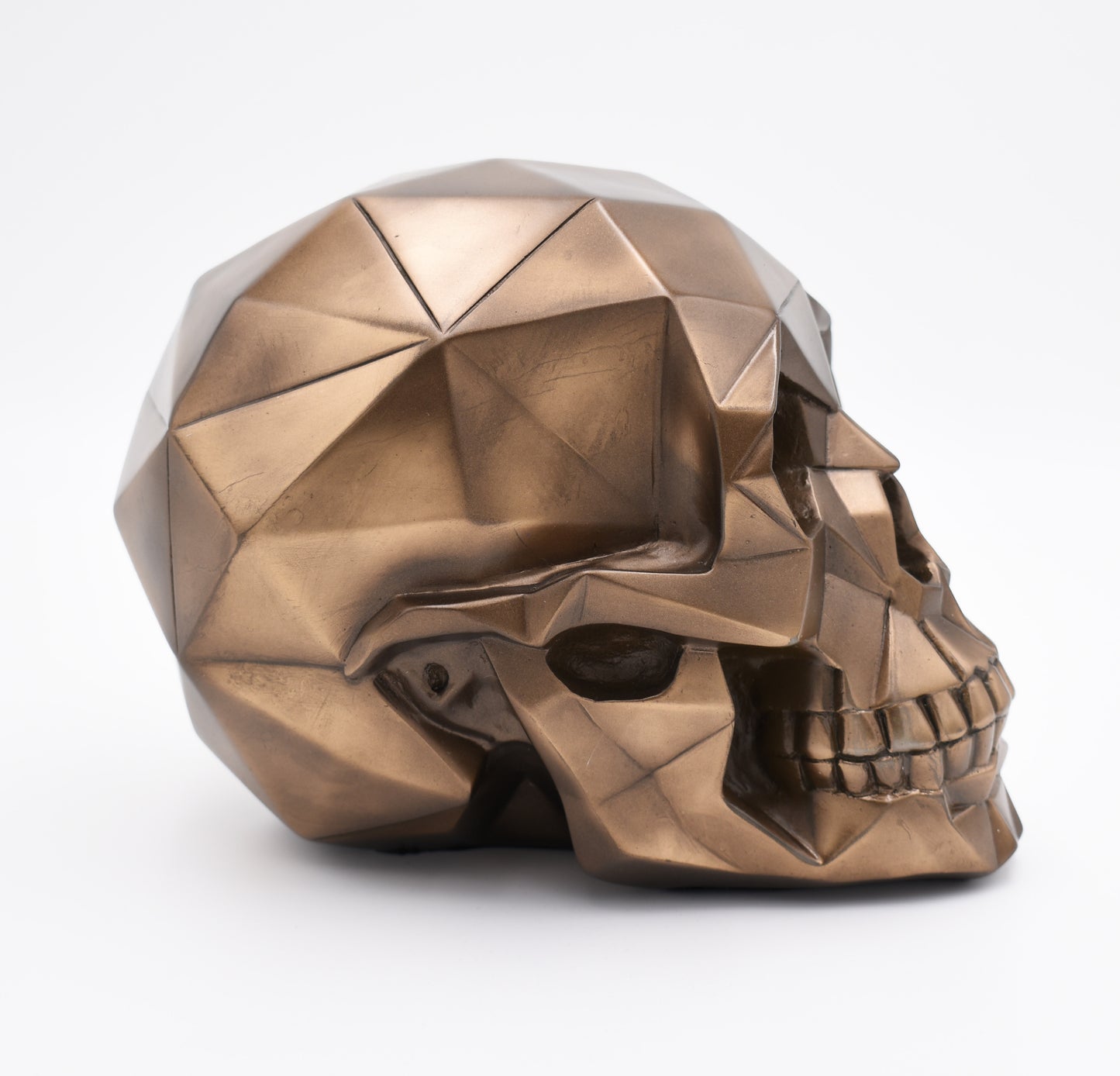 Bronze geometric skull sculpture on a white background