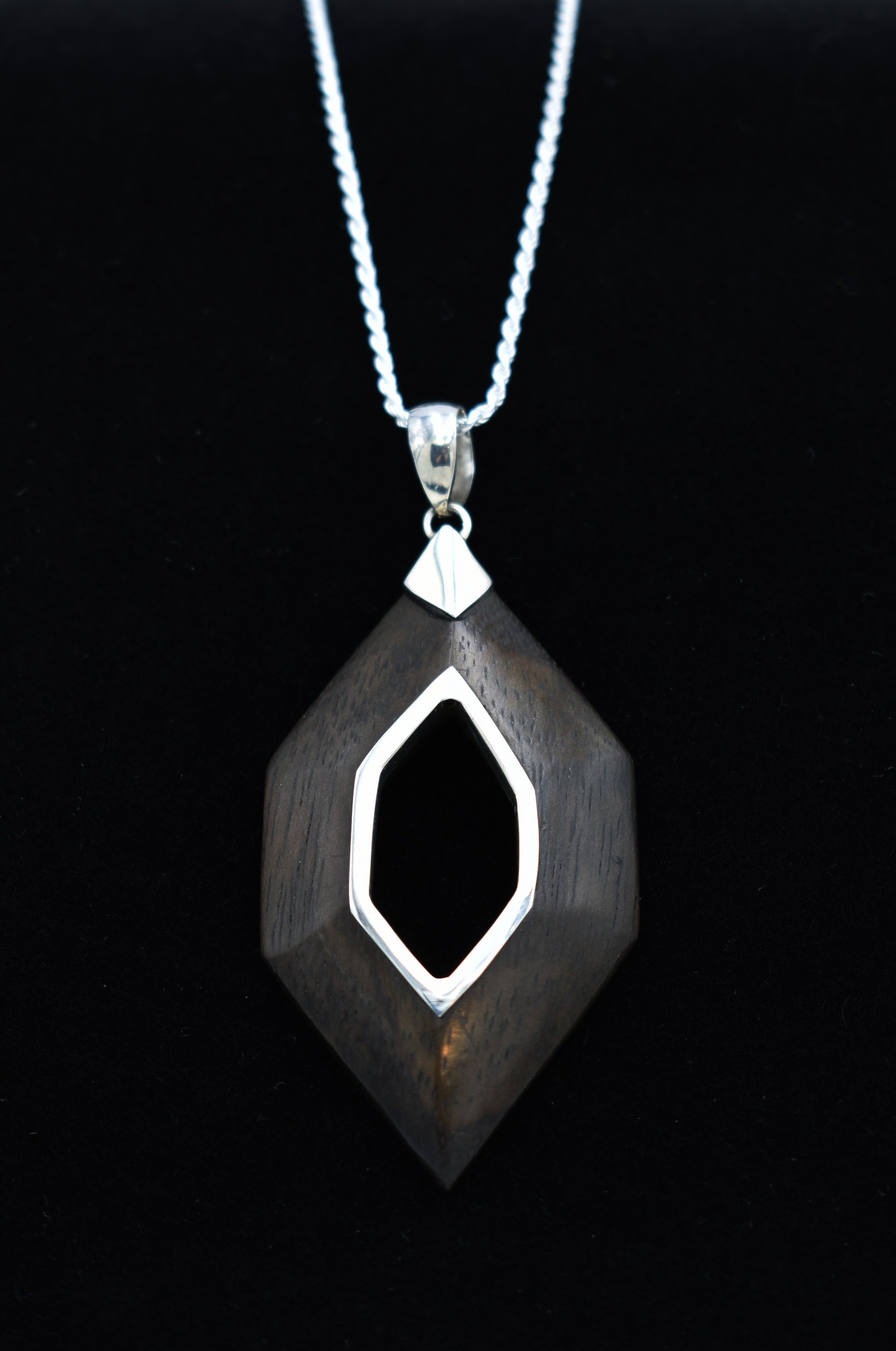 Silver and Sono Wood pendant necklace on a black background