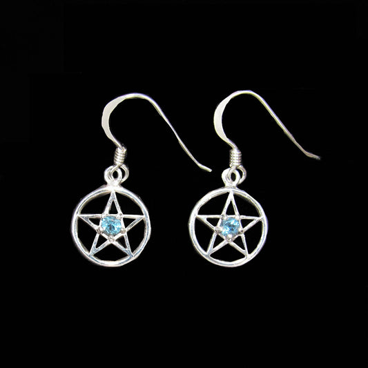 Silver earrings with pentacle designs and blue topaz gemstones on a black background