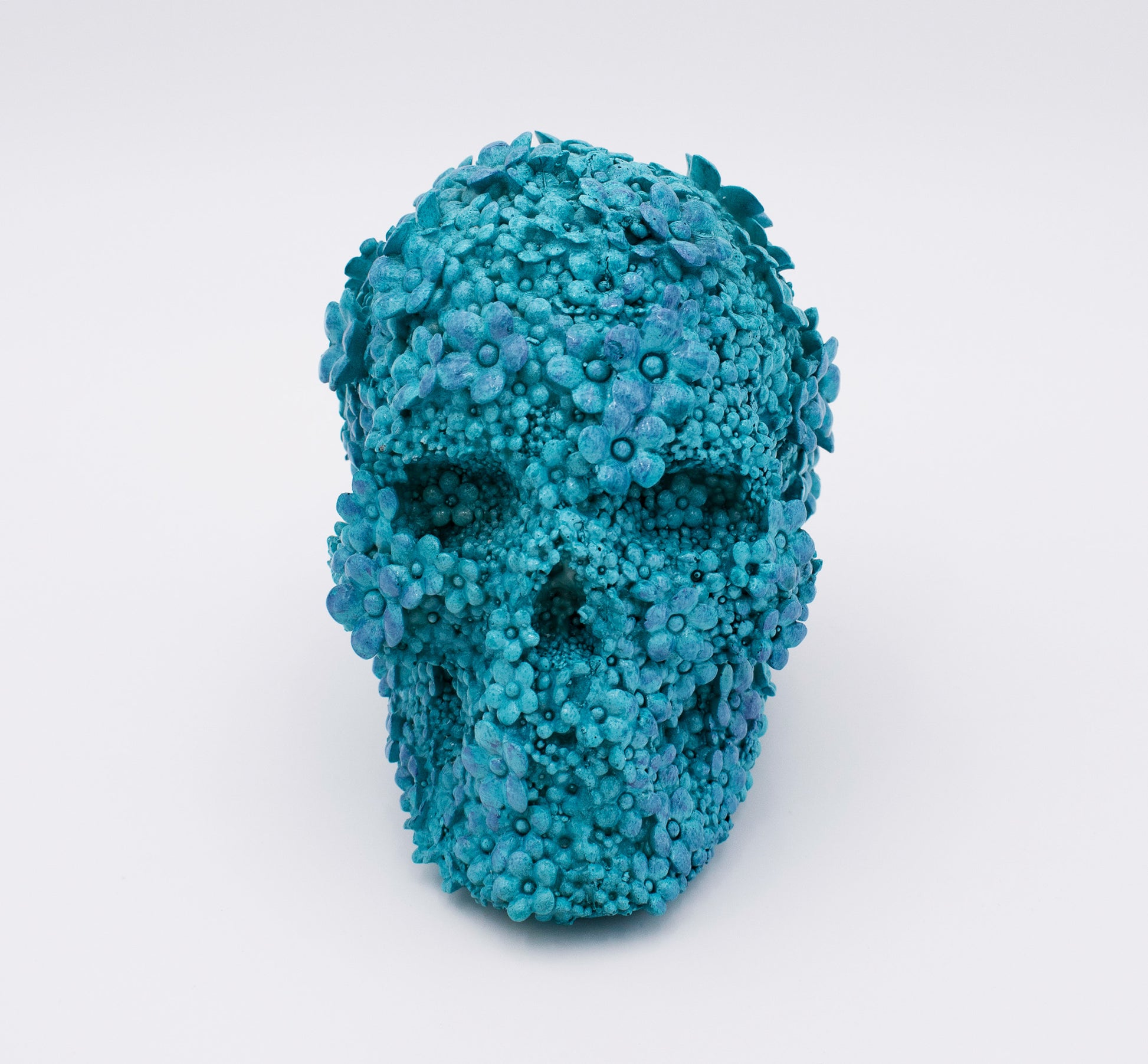 Blue floral skull sculpture on a white background
